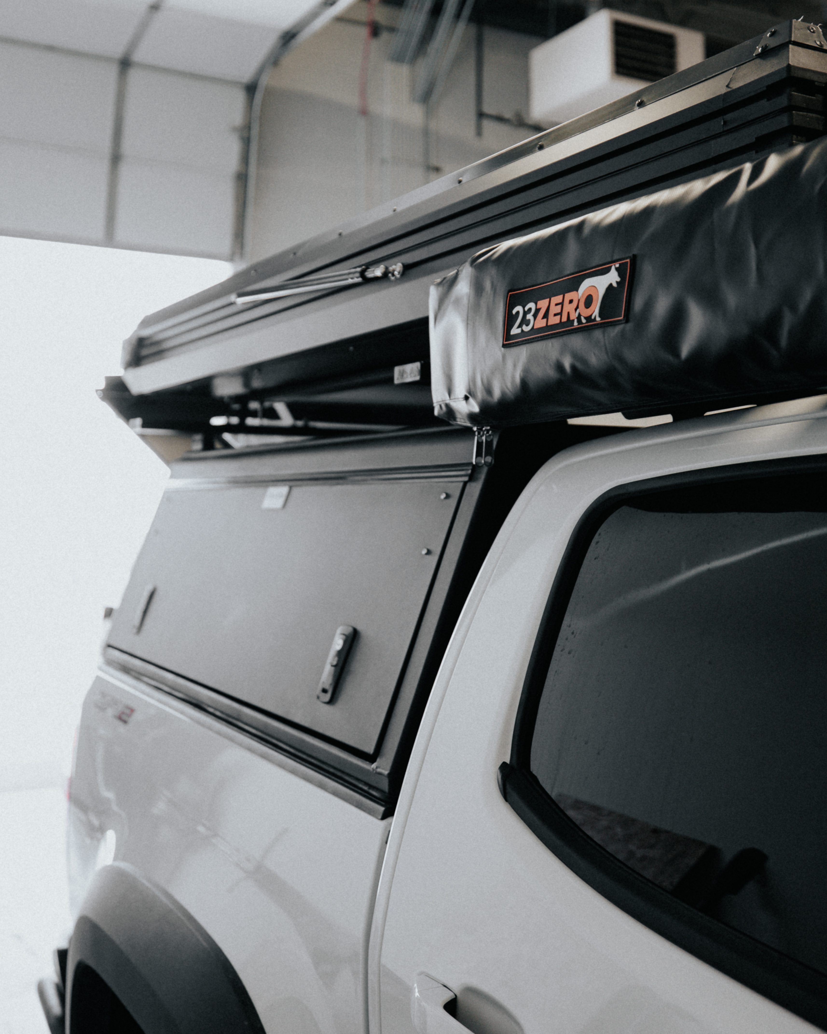 Close view of a 23Zero awning mounted beside a closed rooftop tent on a Chevy Colorado ZR2 Bison